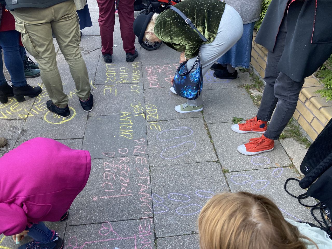 Warszawa. Protest przed komendą Straży Granicznej zgromadził wielu rodziców. Dzieci dostały kredę i obrysowywały swoje stopu