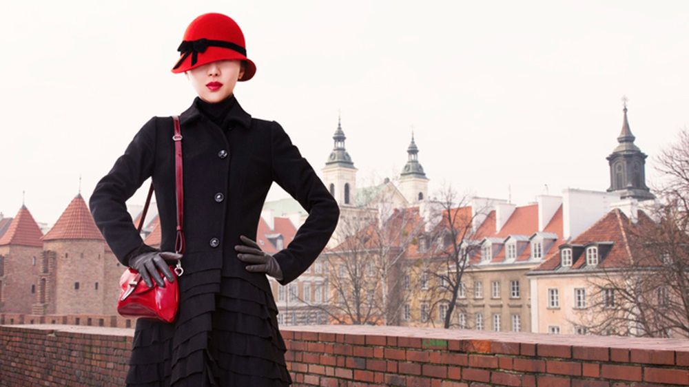 Do stylowego czarnego płaszczyka możesz dobrać elegancką czerwoną minitorebkę oraz kapelusik