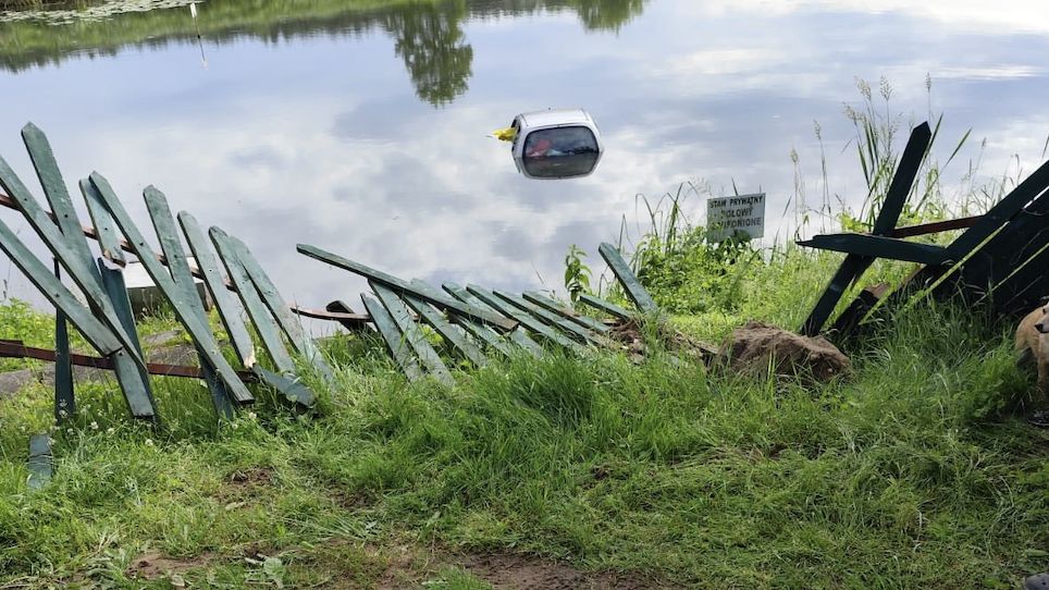 Auto przebiło drewniane ogrodzenie i wjechało do stawu