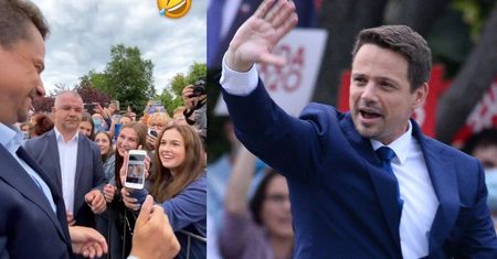 Rozbawiony Rafał Trzaskowski spogląda na mema, na którym jest "CIASTECZKIEM DO KAWUSI" (WIDEO)