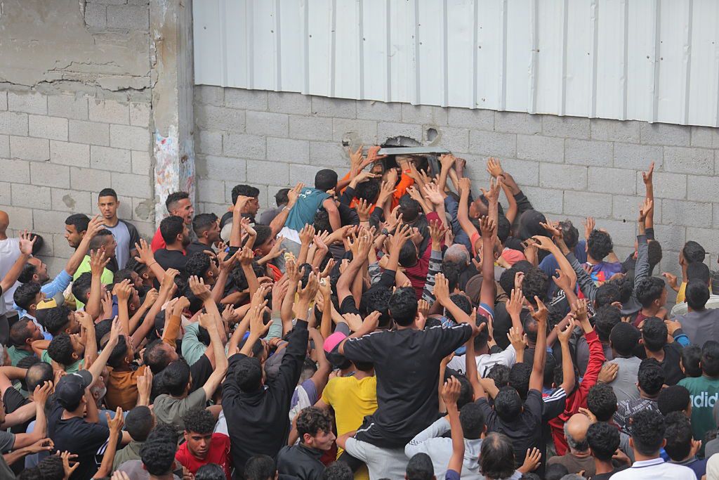 Ludzie czekający na chleb przy oknie piekarni w obozie