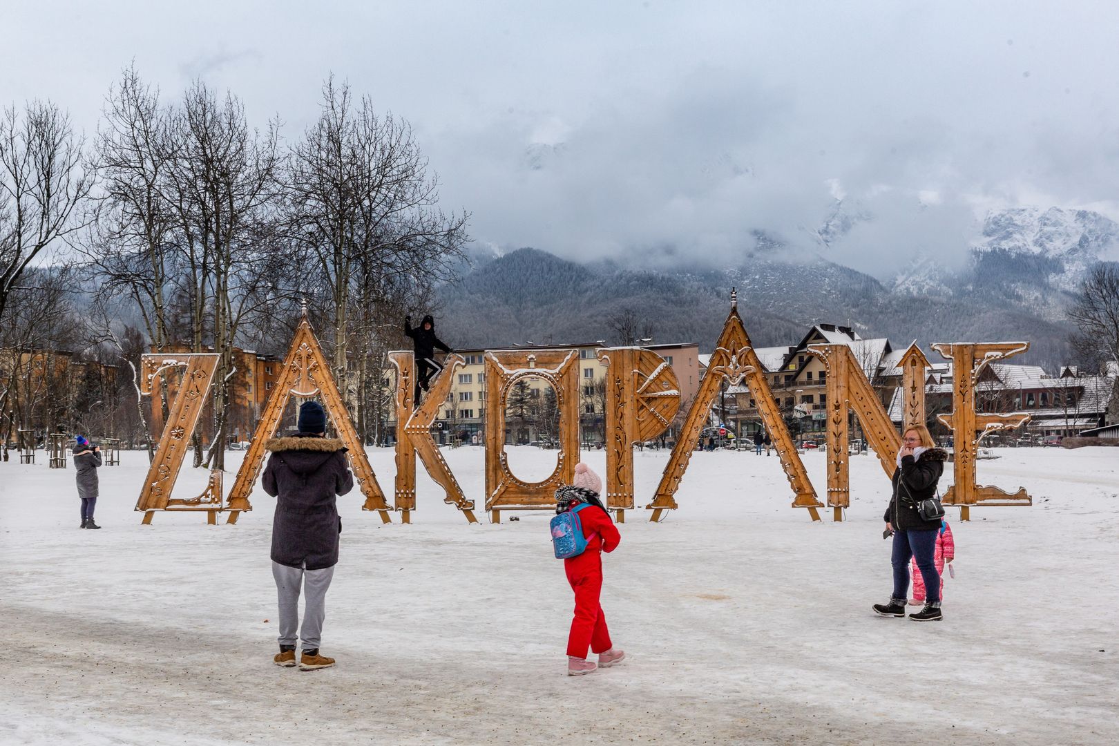 ZAKOPANE, MALOPOLSKIE, POLAND - 2024/01/19: Families take a photo in a public park in front of Zakopane sign in the center of Zakopane a popular Tatra mountain holiday resort. (Photo by Dominika Zarzycka/SOPA Images/LightRocket via Getty Images)