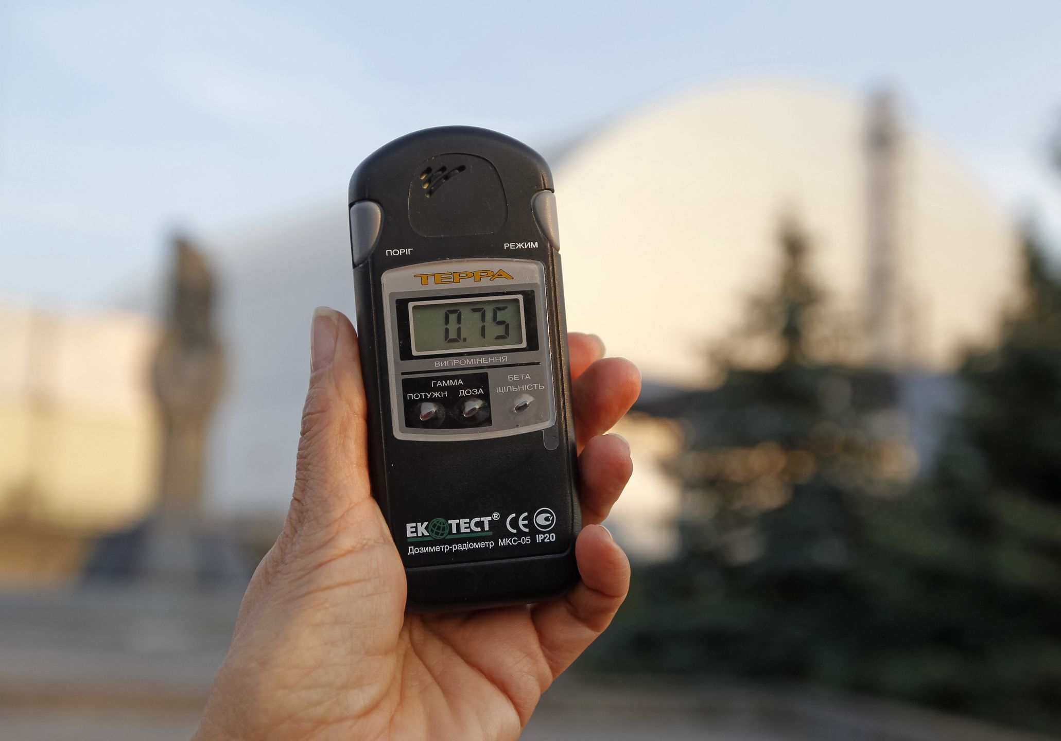 A visitor measures the level of radiation near the Safe Confinement over the 4th block of Chernobyl Nuclear power plant, during a press tour to Chernobyl Exclusion Zone in Chernobyl, Ukraine, on 23 October, 2019. The Chernobyl disaster that occurred on 26 April 1986 at the 4th block of the Chernobyl Nuclear Power Plant, near the city of Pripyat, is considered the worst nuclear disaster in history. (Photo by STR/NurPhoto via Getty Images)