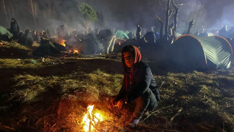 GRODNO REGION, BELARUS  NOVEMBER 17, 2021: A child sits by the fire in a migrant tent camp near the Bruzgi crossing point on the Belarusian-Polish border. The migrant crisis on the border of Belarus with Poland, Lithuania, and Latvia escalated on November 8. Several thousand migrants have approached the Belarusian-Polish border and set up a tent camp there. A large group of migrants spent over two hours throwing stones and other items at Polish border guards at the Kuznica - Bruzgi crossing on November 16, with teargas and stun grenades used in response. Maxim Guchek/BelTA/TASSEDITORIAL USE ONLY; NO COMMERCIAL USE; NO ADVERTISING (Photo by Maxim Guchek\TASS via Getty Images)
