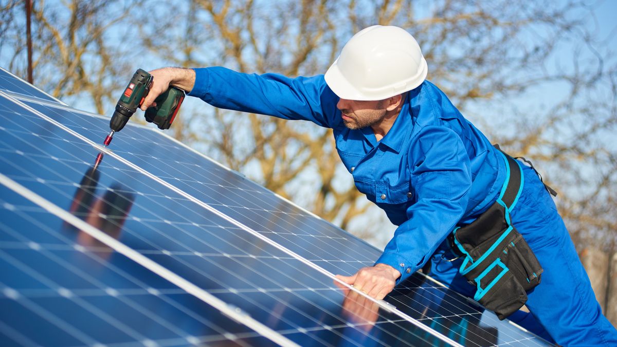 Electrician mounting solar panel on roof of modern houseMan worker in blue suit and protective helmet installing solar photovoltaic panel system using screwdriver. Electrician mounting module on roof of modern house. Alternative energy ecological concept.Anatoliy Glebsolar, panel, electrician, photovoltaic, roof, install, energy, technician, mounting, system, renewable, electric, array, working, ecology, house, voltage, construction, sustainability, green, engineer, home, innovation, batteries, grid, global, technology, efficiency, installation, cells, installer, building, man, generation, maintenance, residential, professional, worker, generator, hands, people, young, helmet, repair, instrument, equipment, screwdriver, environmental, industrial, services