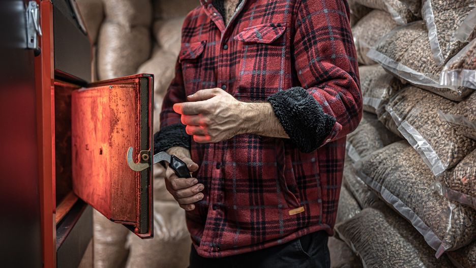 The man with a boiler on solid fuel, open door boiler with flames of fire.