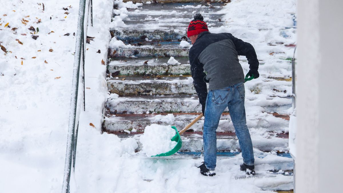 A man is removing snow after the first significant snowfall of the season has hit Krakow, Poland on November 23, 2025. Winter weather with heavy snow and low temperatures has gripped the south and southeast of the country. (Photo by Beata Zawrzel/NurPhoto via Getty Images)