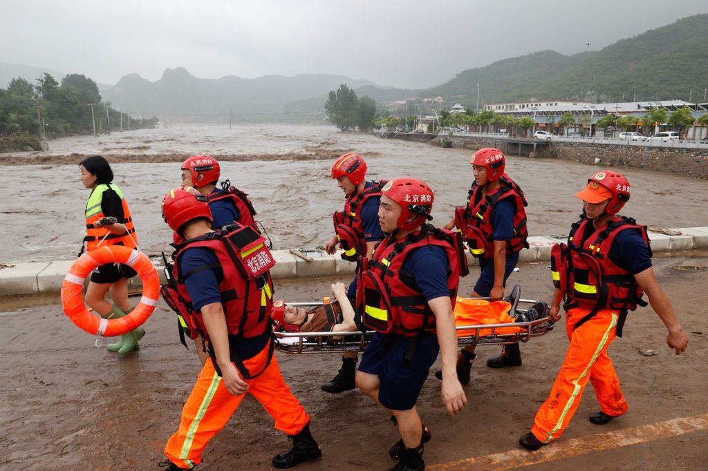 Strażacy ratujący ofiary powodzi