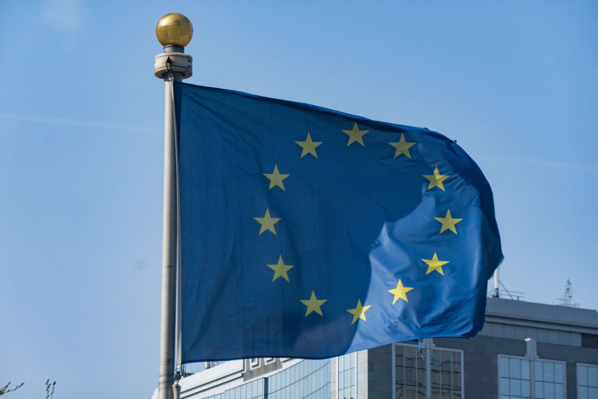 Flag of Europe on flagpole waving in the blue sky on a sunny day among the high buildings in the European capital city Brussels near Brussels North Railway station. The flag of Europe or the European Flag is the symbol of the Council of Europe CoE and The European Union EU as seen in the Belgian capital Brussel. Brussels, Belgium on April 24, 2022 (Photo by Nicolas Economou/NurPhoto via Getty Images)