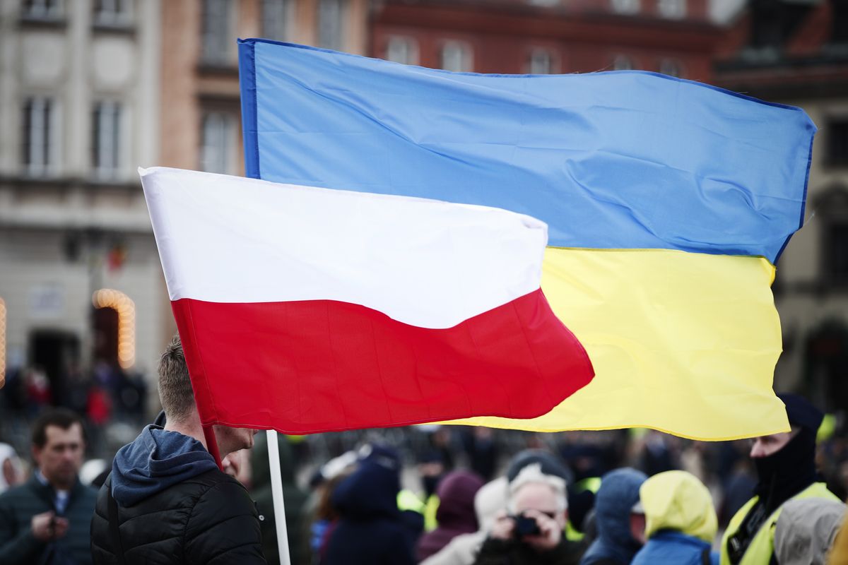 Polish and Ukrainian flags are seen in a crowd gathered to see a speech by US president Joe Biden on March 26, 2022 in Warsaw, Poland. President Biden spent his second day in Warsaw on Saturday visiting refugees from Ukraine in the National Stadium with Rafal Trzaskowski, the mayor of Warsaw and the Polish Prime Minister Mateusz Morawiecki. President Biden also gave a fiery speech against the Russian invasion of Ukraine while assuring that NATO will defend all its member states against any aggression at all costs. (Photo by STR/NurPhoto via Getty Images)