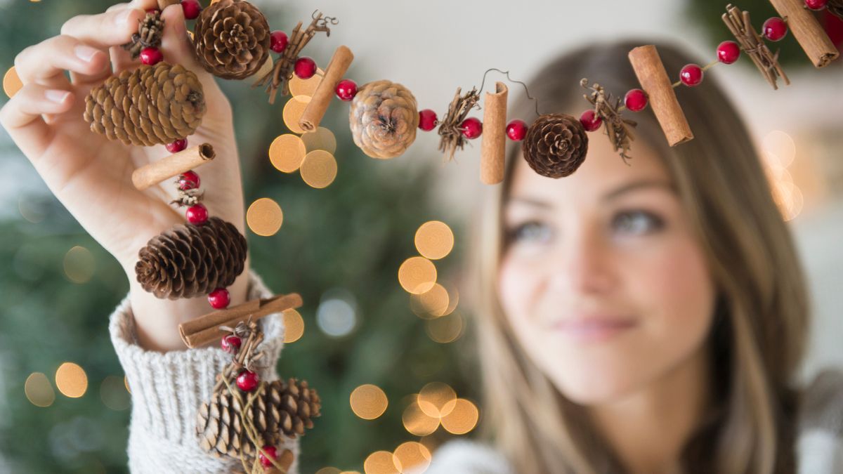 Kobieta trzyma w rękach łańcuch świąteczny