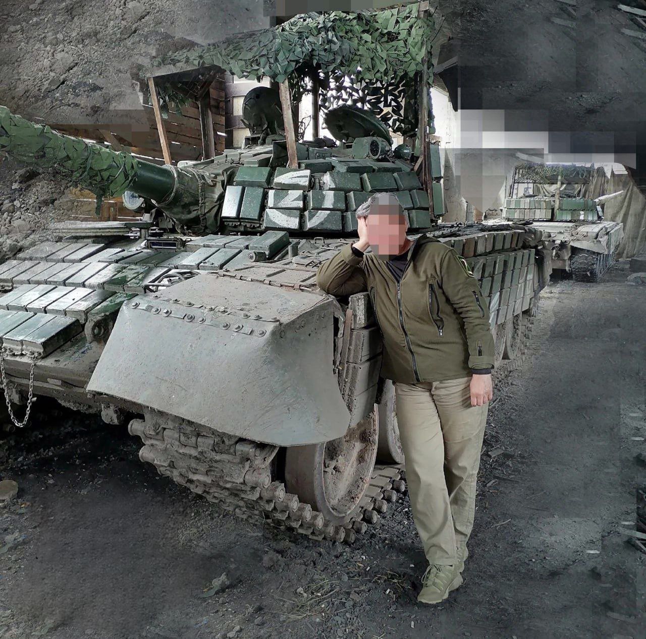 Rosyjski żołnierz na tle swojego zmodernizowanego zabytkowego czołgu T-72 Ural.