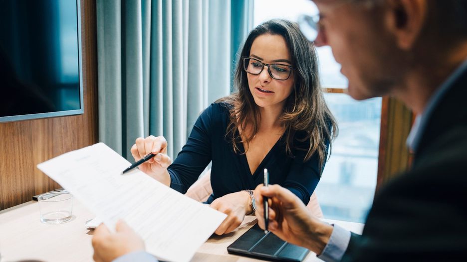 Male and female entrepreneur brainstorming over document during meeting in office