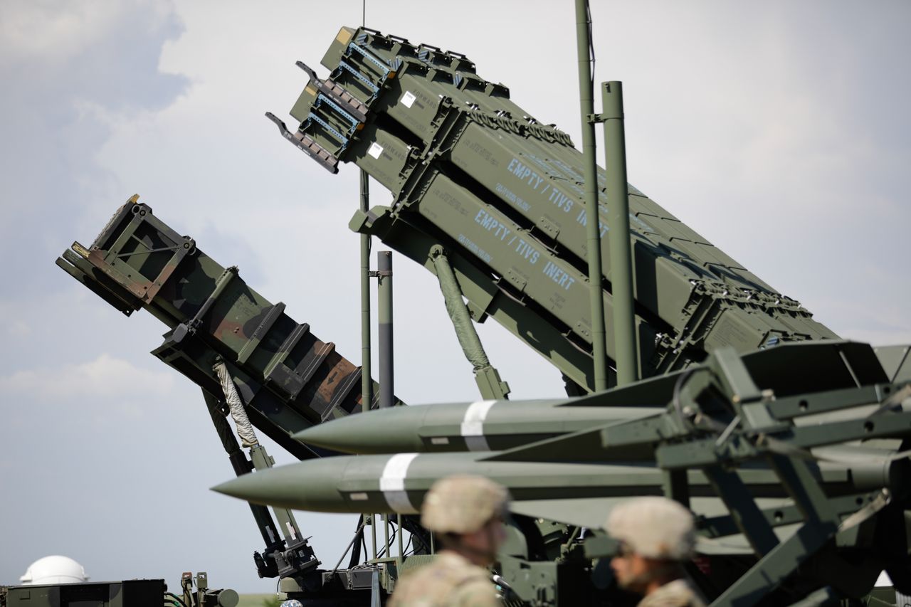 Romanian Patriot system launchers against the backdrop of an older MIM-23 Hawk set.