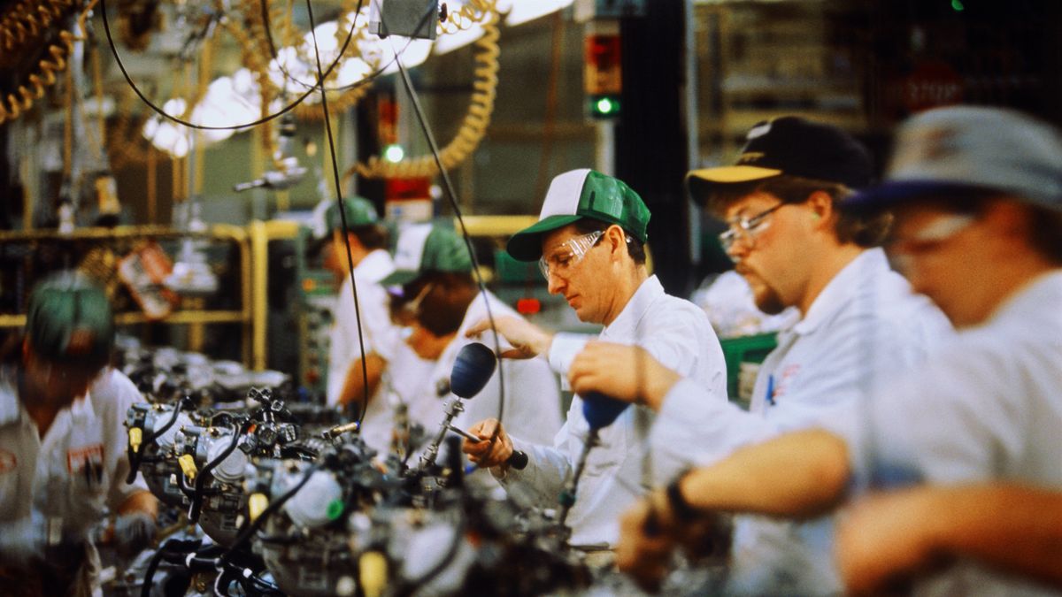 Car engine assembly, workers adjusting engine block valve
Honda Plant, Ohio, USA.
Andy Sacks