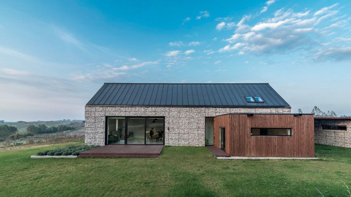 The facade is made of gabion baskets and a parquet on the wall.  An unusual house in the style of a modern barn