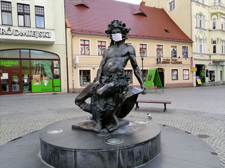 Pomnik w centrum miasta zyskał maseczkę ochronną. Mieszkańcy miasta korzystają z takich zabezpieczeń znacznie rzadziej.