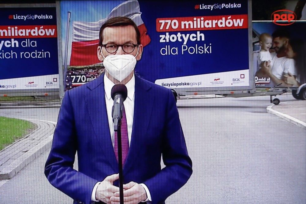 <p>Warszawa, 27.04.2021. Koronawirus w Polsce. Premier Mateusz Morawiecki podczas konferencji prasowej transmitowanej przez serwis pap.pl i ogl¹danej w jednym z mieszkañ w Warszawie, 27 bm. W Sejmie rano odby³o siê spotkanie premiera Morawieckiego i przedstawicieli rz¹du oraz klubu PiS z politykami Lewicy nt. Krajowego Planu Odbudowy. (mr) PAP/Rafa³ Guz</p>