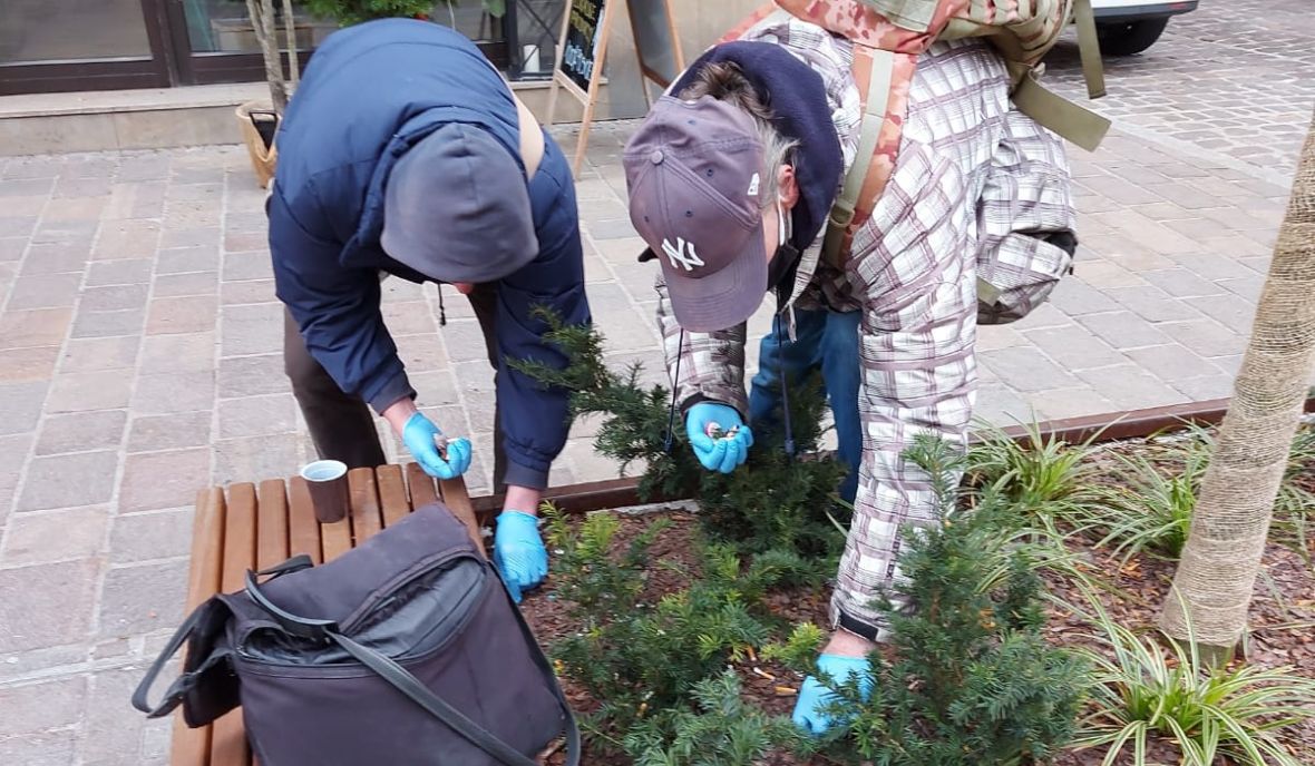 Podopieczni krakowskiego ośrodka sprzątają klomb przed wejściem