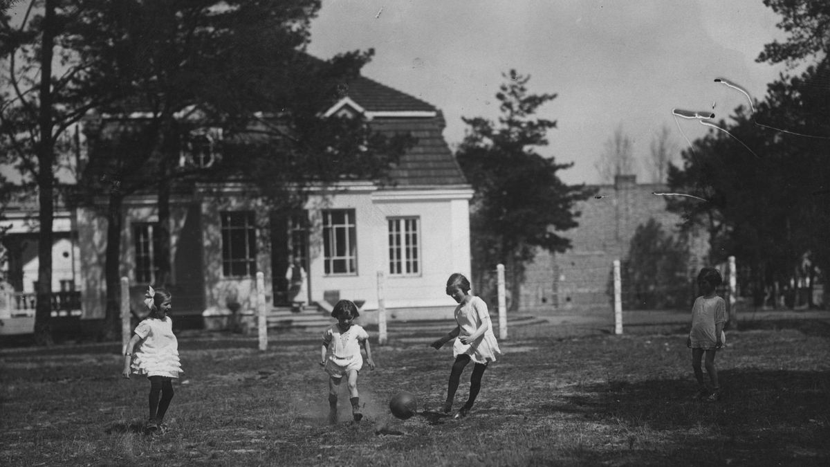 Dzieci bawią się piłką przed domem