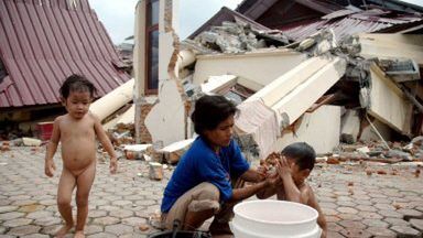 Matka z dziećmi przed zawalonym domem na wyspie Nias