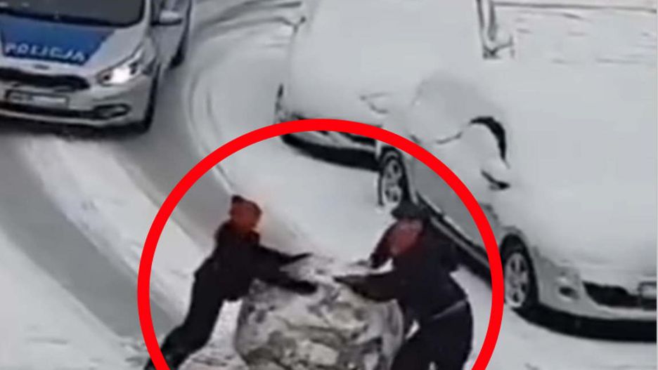 Dzieci próbują przesunąć wielką kulę śniegu. Nagle nadjeżdża policja