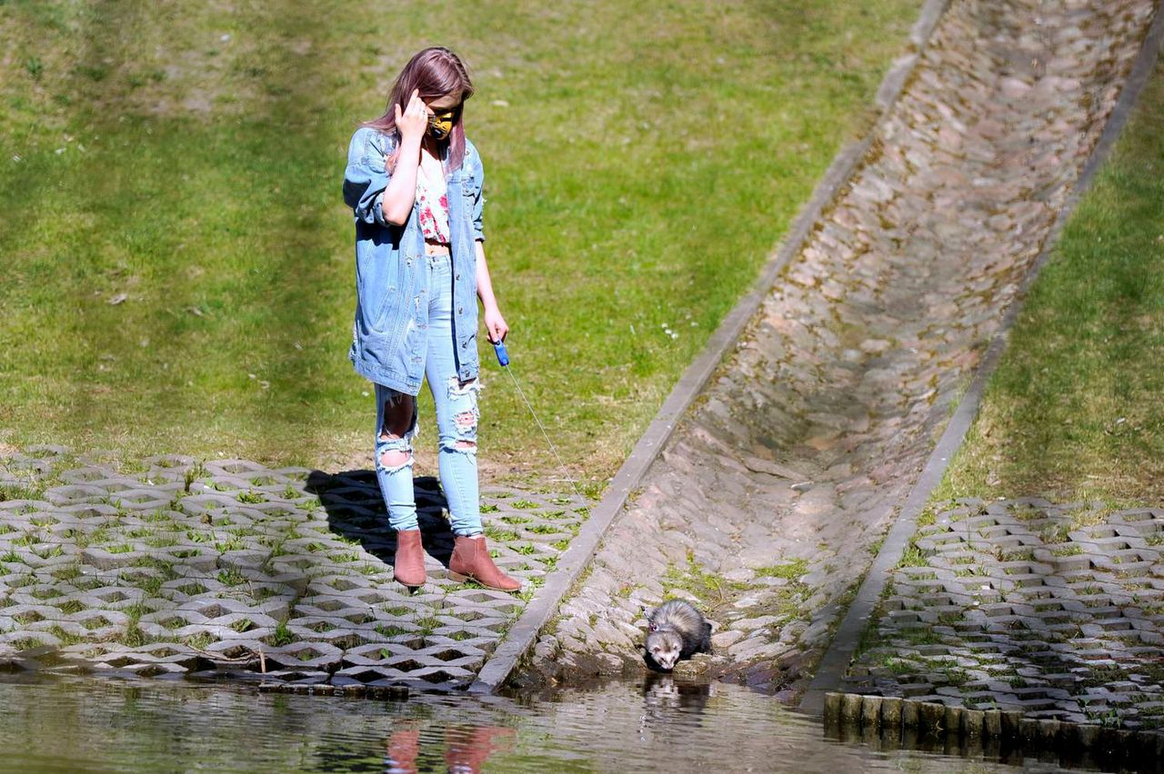 Julia Wróblewska w dżinsie w parku z fretką
