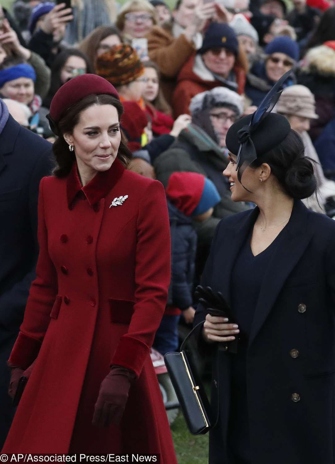 Księżna Kate w czerwonym płaszczu i Meghan Markle w czarnym komplecie na świątecznej mszy