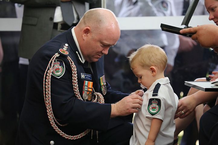 Komisarz straży pożarnej przekazał chłopcu podczas pogrzebu medal za odwagę jego taty. 