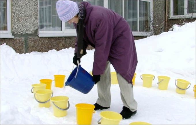 Kobieta przygotowuje wiaderka z wodą