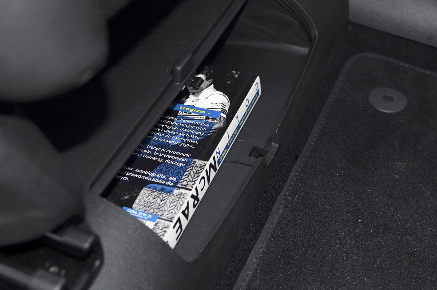 foto: coś dla rodzica – skrytka na książkę pod fotelem pasażera z przodu.