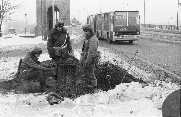 Żołnierze z wojskowego patrolu na moście Poniatowskiego ogrzewają się przy koksowniku