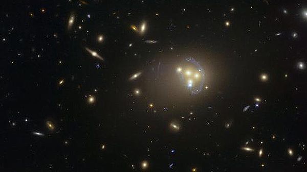 Zdjęcie gromady galaktyk Abell 3827 wykonane za pomocą Kosmicznego Teleskopu Hubble&#8217;a. Dziwne niebieskie struktury wokół centralnych galaktyk to obrazy soczekowania grawitacyjnego znacznie odleglejszej galaktyki.