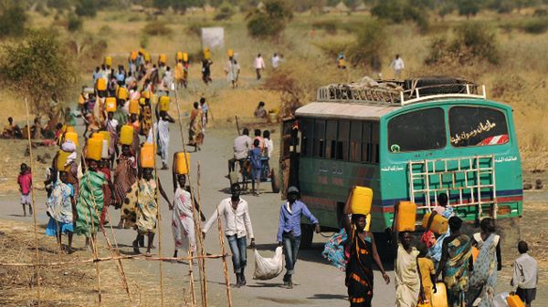 Wewnętrzni uchodźcy w Sudanie Płd.; niosą wodę do misji ONZ, gdzie się schronili przed walkami