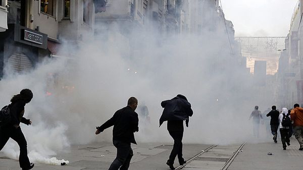 Ludzie uciekają przed kłębami gazu łzawiącego w Stambule