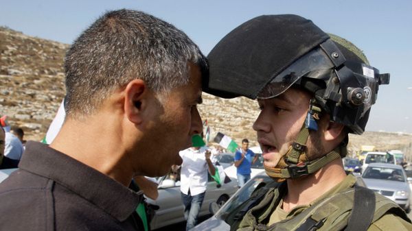 Izraelski żołnierz kłóci się z Palestyńczykiem podczas protestu w Beit Ur na Zachodnim Brzegu