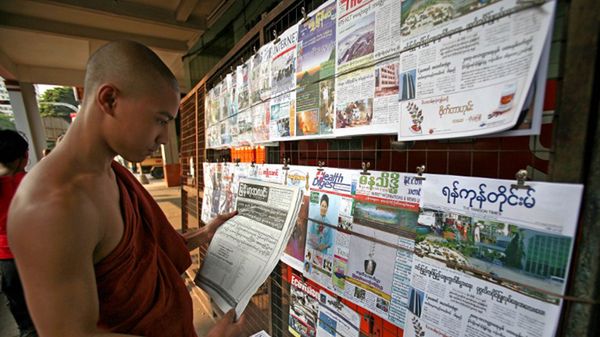 Mnich przy stoisku z prasą w Birmie