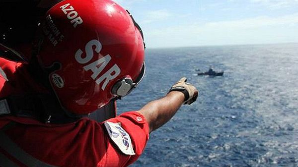 Ratownik na pokładzie śmigłowca wskazuje miejsce odnalezienia wraku