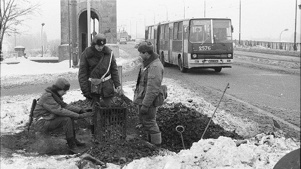 Żołnierze z wojskowego patrolu na moście Poniatowskiego ogrzewają się przy koksowniku