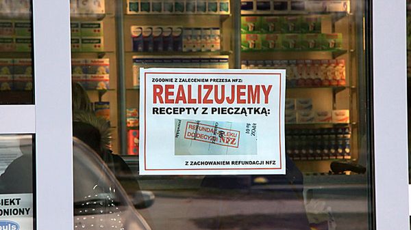 Naklejka informująca o realizacji recept z pieczątką "Refundacja do decyzji NFZ" na jednej z aptek.