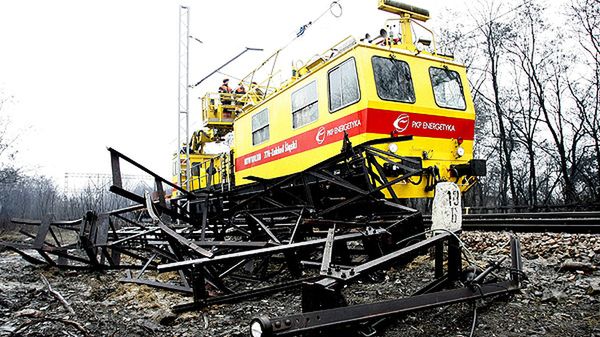 Pojazd energetyków przy przewróconym przez silny wiatr słupie trakcyjnym - zdjęcie archiwalne