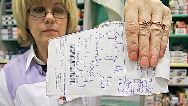 Farmaceutka prezentuje receptę, na której lekarz dopisał "refundacja do decyzji NFZ".