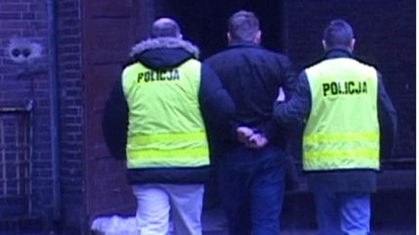 Policjanci prowadzą zatrzymanego mężczyznę