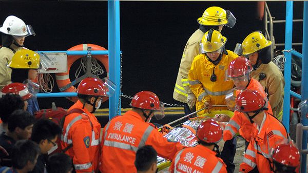 Ratownicy przenoszą osobę ranną w wyniku zderzenia promu z holownikiem u południowych wybrzeży Hongkongu