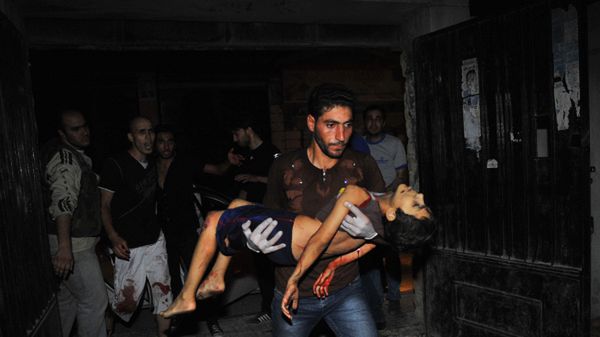 Mężczyzna niesie chłopca rannego w czasie ostrzału Aleppo