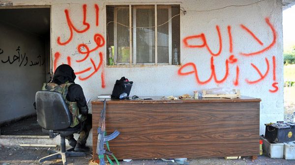 Syryjski bojownik deklarujący się jako członek grupy "Szura Taliban Islam". Napis po prawej stronie: "Nie ma boga prócz Allaha", po lewej: "Rozwiązaniem jest Islam" - sztandarowe hasło Bractwa Muzułmańskiego