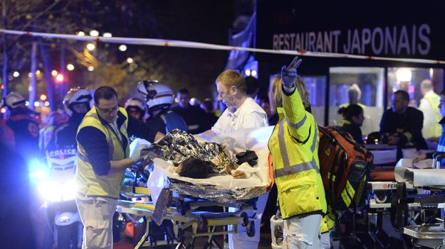 Ratownicy udzielają pomocy rannemu w zamachu w Paryżu w listopadzie 2015 r.