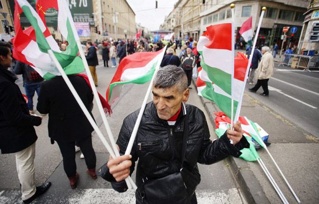 Mężczyzna z flagami Węgier na ulicy Budapesztu w 60 rocznicę rewolucji węgierskiej