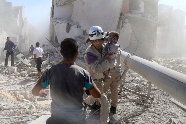 Ratownik pomaga rannemu dziecku po rzekomym ataku z użyciem bomby beczkowej, Aleppo, wrzesień 2014 r.