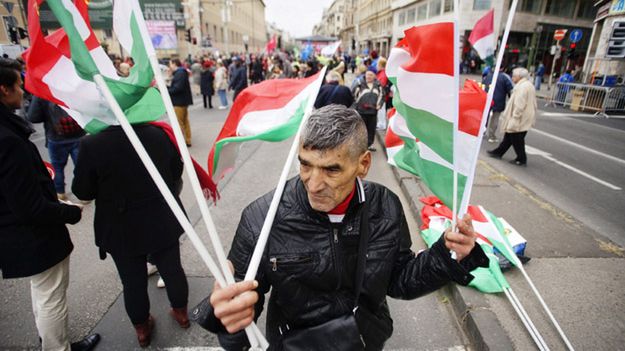 Mężczyzna z flagami Węgier na ulicy Budapesztu w 60 rocznicę rewolucji węgierskiej